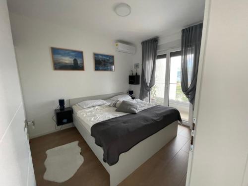 a bedroom with a bed in a room with a window at Apartma LAVANDA 3 Šilo in Šilo