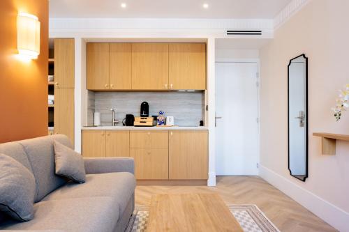 a living room with a couch and a kitchen at Résidence Monceau Jadin in Paris
