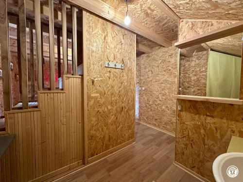 a bathroom with wooden walls and a toilet in it at Le gîte des oiseaux in Aisy-sous-Thil