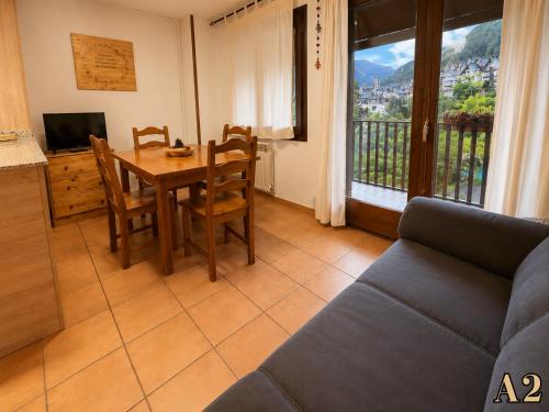 a living room with a table and a couch at Hostal Rural Sant Climent - Habitacions i Apartaments in Taüll