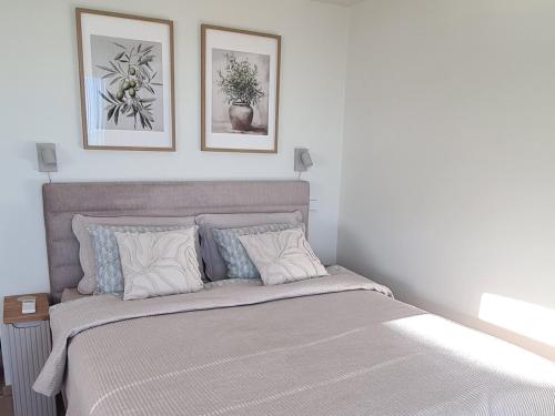 a bedroom with a bed with two pictures on the wall at Seaside Getaway Apartment in Haapsalu