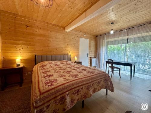 a bedroom with a bed and a table and a desk at Le gîte des oiseaux in Aisy-sous-Thil