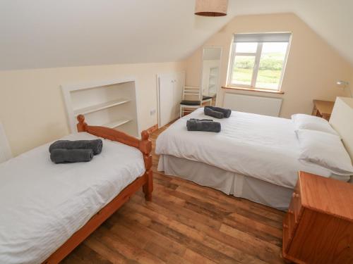 a bedroom with two beds and a window at Islands Inn in Louisburgh
