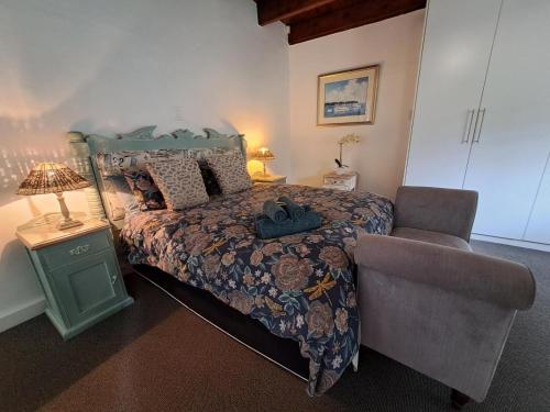 a bedroom with a bed and a chair at Fiore Guest Accommodation in Greyton