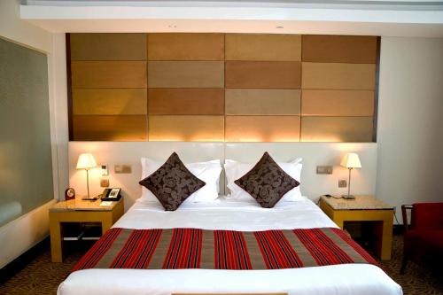 a hotel room with a large bed with two lamps at The Boma Nairobi in Nairobi