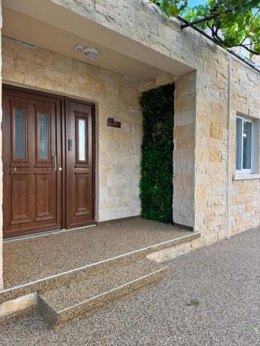 a house with a wooden door and a stone wall at Le AVRA MONTIS in Galata