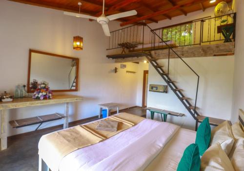 a living room with a bed and a staircase at Amber Reach Cottages in Ella
