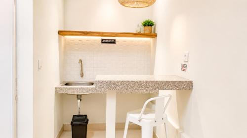 a small kitchen with a sink and a white stool at Baliem Boutique Hotel Ungasan in Jimbaran
