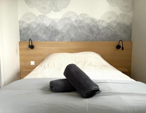 a bed with two pillows on top of it at Relais Fléchois in La Flèche