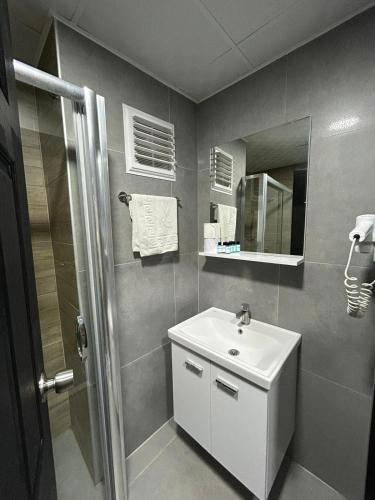 ein Badezimmer mit weißem Waschbecken und Dusche in der Unterkunft Belsea Hotel in Beldibi