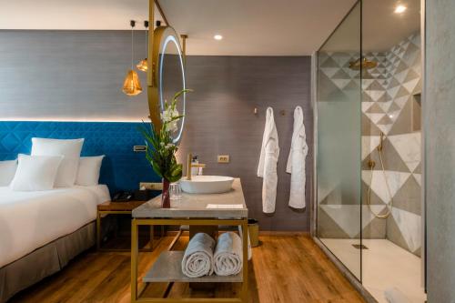 a bedroom with a bed and a shower and a sink at Barceló Anfa Casablanca in Casablanca