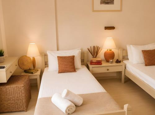 two beds in a room with two lamps and towels at Bright 2BR Apt Kitchenette Pool 3 in Gouvia