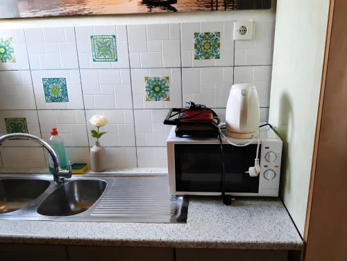 a kitchen counter with a sink and a microwave at Family 2BR Apt Kitchenette Pool 7 in Gouvia