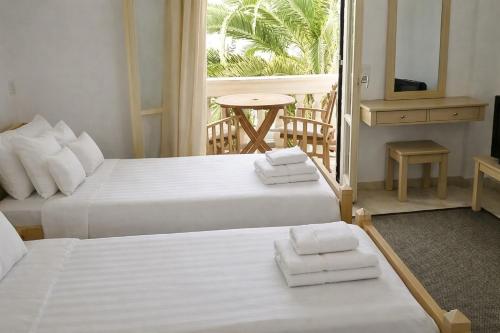 two beds in a hotel room with a balcony at 2BR Apt Kitchenette Pool 6 in Gouvia