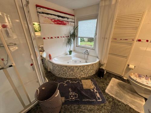 a bathroom with a tub and a toilet and a sink at Ferienwohnung Sorpesee in Sundern