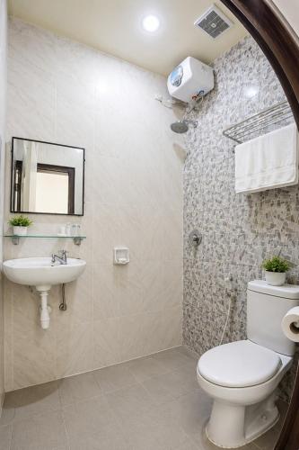 a bathroom with a toilet and a sink at Mahkota Hotel in Genteng-kulon