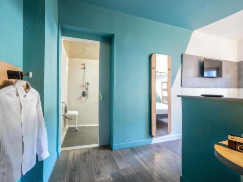 a bathroom with blue walls and a mirror at Ibis Budget Sucy en Brie in Sucy-en-Brie