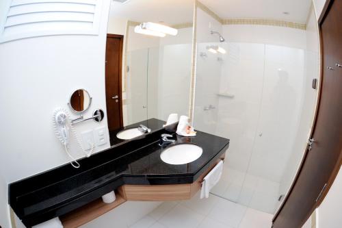 
a bathroom with a shower, sink, and mirror at Faria Lima Flat Service in Sao Jose do Rio Preto
