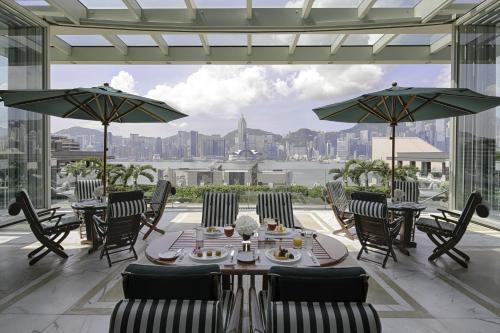 a restaurant with tables and chairs and a view of the city at The Peninsula Hong Kong in Hong Kong