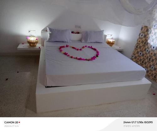 a bed with a heart made out of flowers on it at Tranquil villa in Watamu