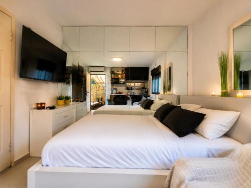 a bedroom with a large white bed and a couch at Spa Mari TLV in Tel Aviv