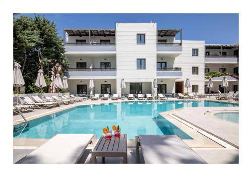 a swimming pool with chairs and a hotel at Summer Dream in Rethymno