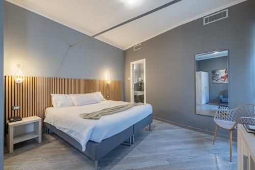 a bedroom with a large bed and a table at PRIMA FILA Premium Guest House in Sanremo