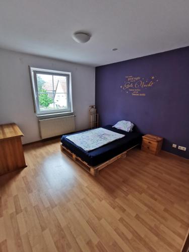 a bedroom with a bed and a purple wall at Ferienwohnung Münsingen zentrum in Münsingen