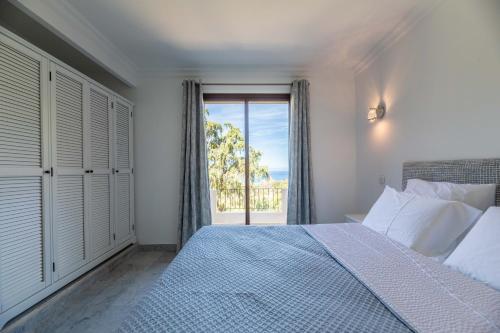 a bedroom with a bed and a large window at Villa Excelsior in Porto Ota