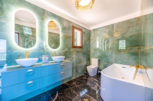 a bathroom with two sinks and a tub at Villa Excelsior in Porto Ota