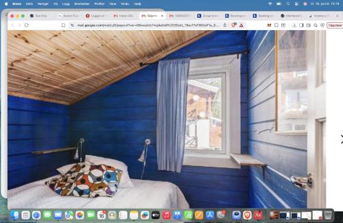 a blue room with a bed with a window at Villa Bearcorner in Härbyste