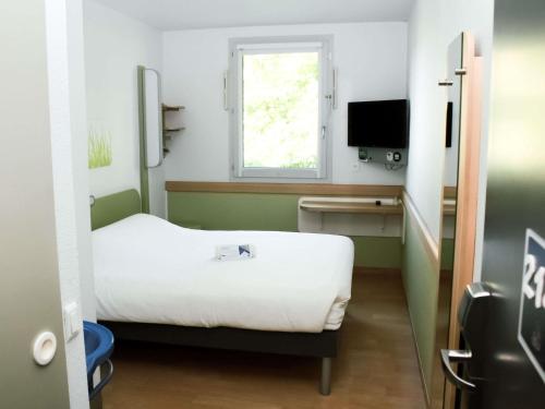 a small room with a bed and a window at ibis budget Saint-Omer Centre in Saint-Omer