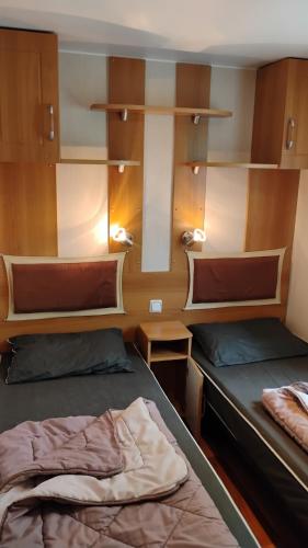 a room with two beds and shelves on a boat at Mobilhome 713 panoramique Siblu in Gastes