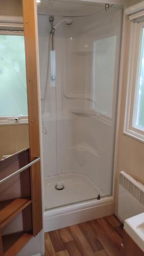 a shower with a glass door in a bathroom at Mobilhome 713 panoramique Siblu in Gastes