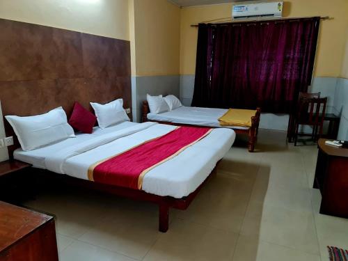 two beds in a hotel room with at Hotel Royal Park in Mangalore