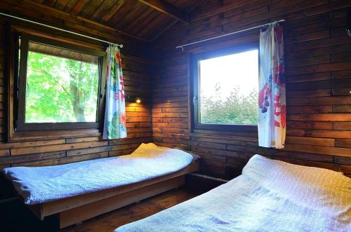 sypialnia z 2 łóżkami w drewnianym domku w obiekcie Ośrodek Wypoczynkowy Sielawa w mieście Chrzypsko Wielkie