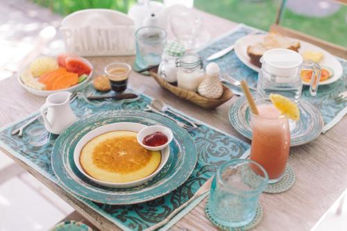 a table with a bowl of soup and a plate of food at Palmeto Village in Gili Trawangan