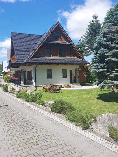 a house with a gambrel roof on a yard at ZYCH - Domek in Chochołów