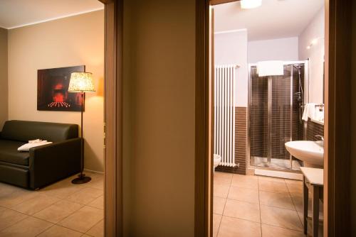 a bathroom with a couch and a sink in a room at Santa Giulia Hotel e Residence Torino in Turin
