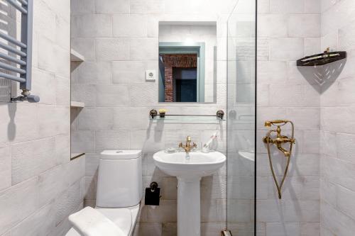 a white bathroom with a toilet and a sink at Ethno Sololaki in Tbilisi City