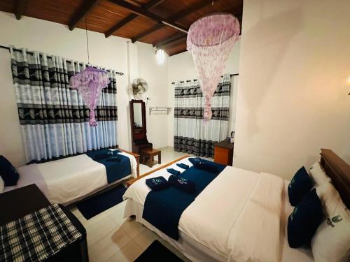 a bedroom with two beds and two windows with curtains at Green Village in Ella
