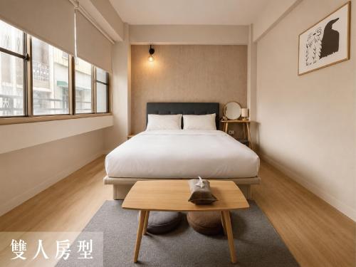 a bedroom with a bed and a coffee table at Littlesay in Tainan