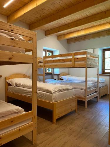 a room with three bunk beds in a cabin at Malga Valmaggiore in Bellamonte