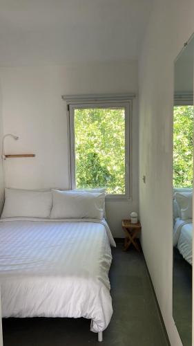 a bedroom with a large white bed with a window at Arazzo Apartments in Modena