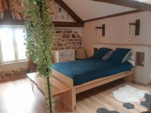 a bedroom with a bed with blue sheets and a plant at Gîte de l'Ancienne Forge in Epfig