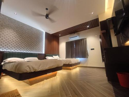 a bedroom with two beds and a window at Hotel J VIN PALACE in Mysore