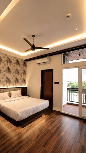 a bedroom with a bed and a ceiling fan at Hotel J VIN PALACE in Mysore