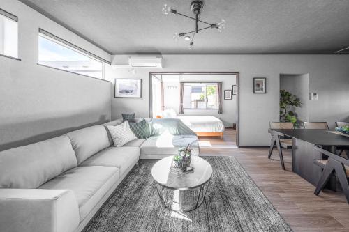 a living room with a white couch and a table at Hoshiyado Nagayama in Asahikawa