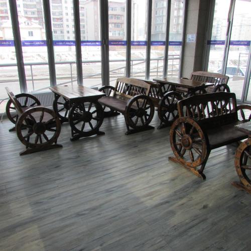 a group of tables and benches in a room with windows at J Hotel in Ulaanbaatar