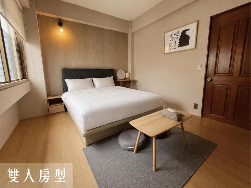 a small bedroom with a bed and a table at Littlesay in Tainan